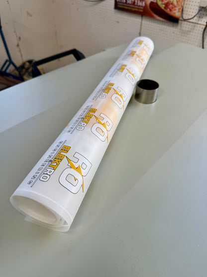Roll of paper with branding on a light-colored surface